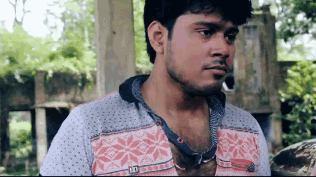 a man wearing a shirt with the letter e on it looks at the camera