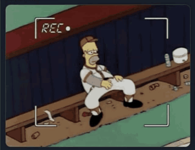 a cartoon of homer simpson sitting on a bench in a dugout being recorded