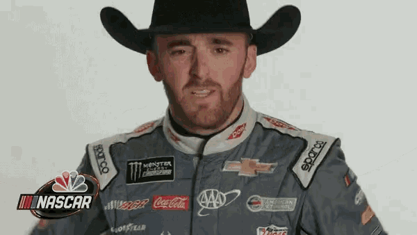 a man in a cowboy hat is wearing a nascar jacket