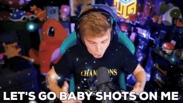 a man wearing headphones is sitting in front of a microphone and says let 's go baby shots on me .