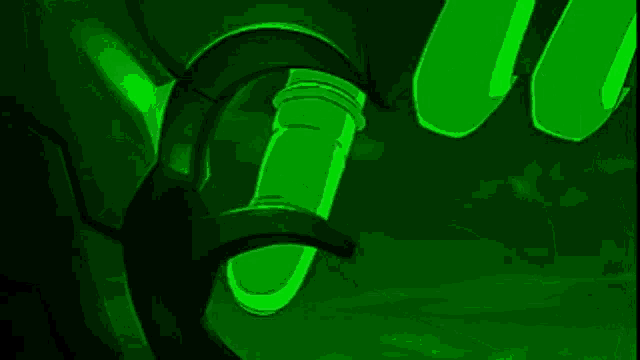a person is holding a green shield in front of a green light .