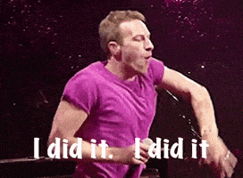 a man in a purple shirt is singing into a microphone and says " i did it "