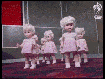 a bunch of dolls are walking in a line with british pathe on the bottom