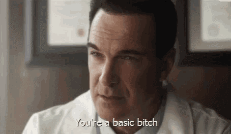 a man in a white lab coat is sitting in a chair and talking to someone .