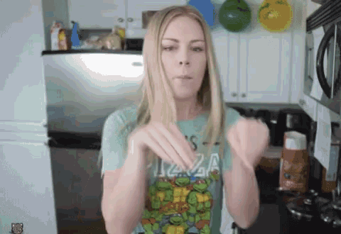 a woman wearing a teenage mutant ninja turtle shirt makes a funny face