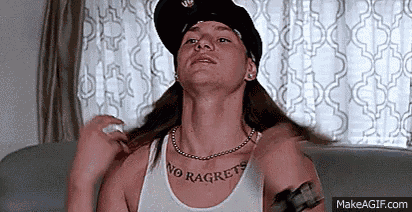 a woman wearing a hat and a necklace is sitting on a couch and looking up .