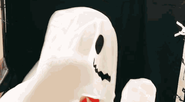 a person in a white ghost costume with a black face