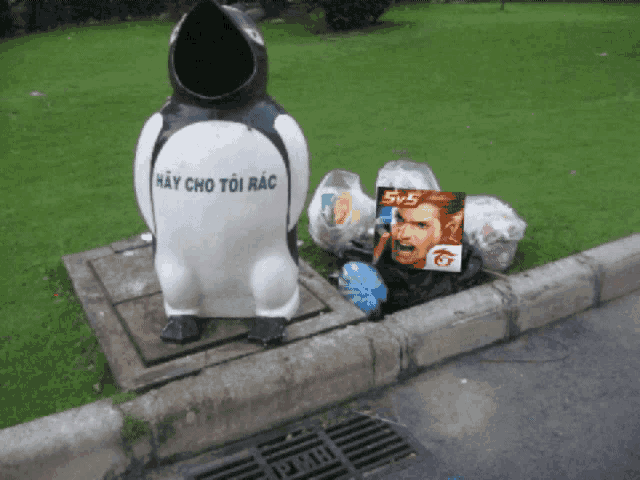 a statue of a penguin with hay cho toi rac written on its back