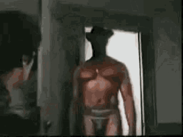 a man is standing in front of a mirror looking at a naked man in underwear .