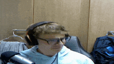a man wearing headphones and glasses looks at the camera