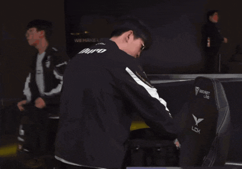 a man giving a thumbs up wearing a jacket that says gen.g on it