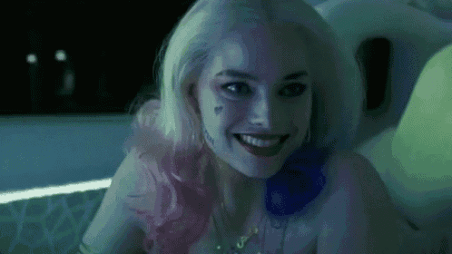 a close up of a woman in a suicide squad costume smiling .