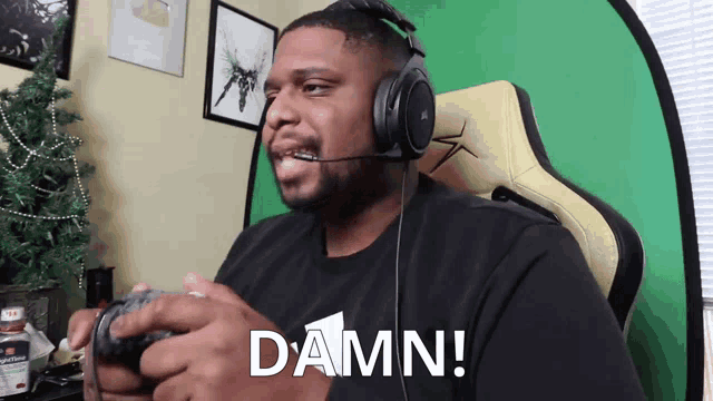 a man wearing headphones and a black shirt with the word damn on it