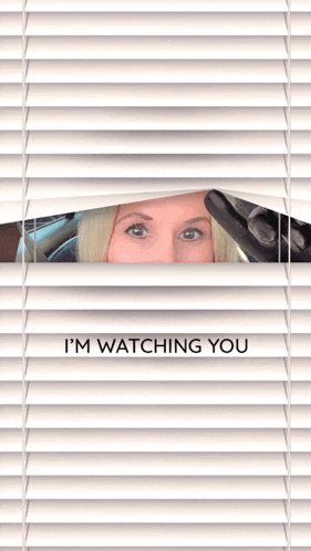 a woman peeking through blinds with the words " i 'm watching you "