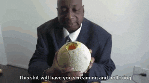 a man in a suit and tie is holding a melon with a hole in it and says this shit will have you screaming