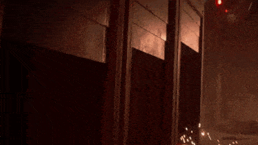 a group of soldiers are standing in a dark room with a red light in the background