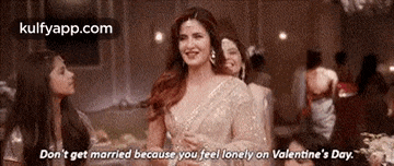 a woman in a white dress is talking to another woman while standing in a room .