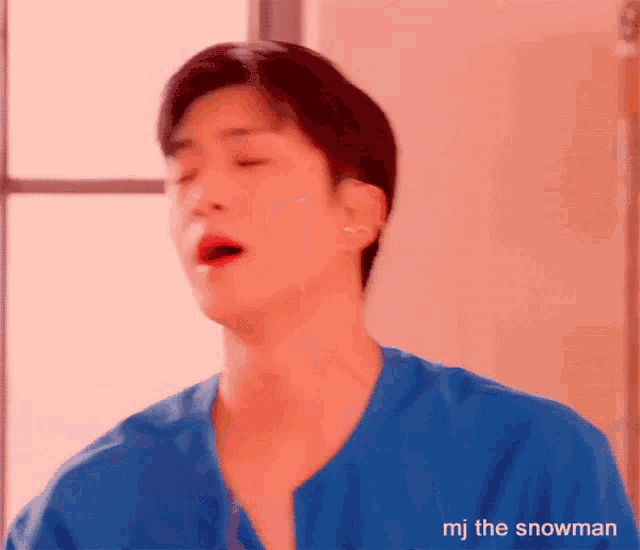 a man wearing a blue shirt with the name mj the snowman on the bottom