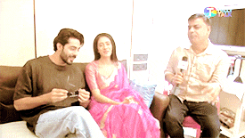 a man is holding a microphone while sitting next to two women
