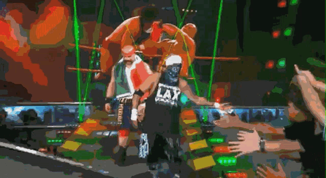 a wrestler wearing a lax shirt is walking down the ring
