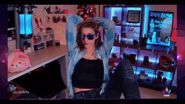 a woman wearing sunglasses is sitting in front of a sign that says stream boss on it