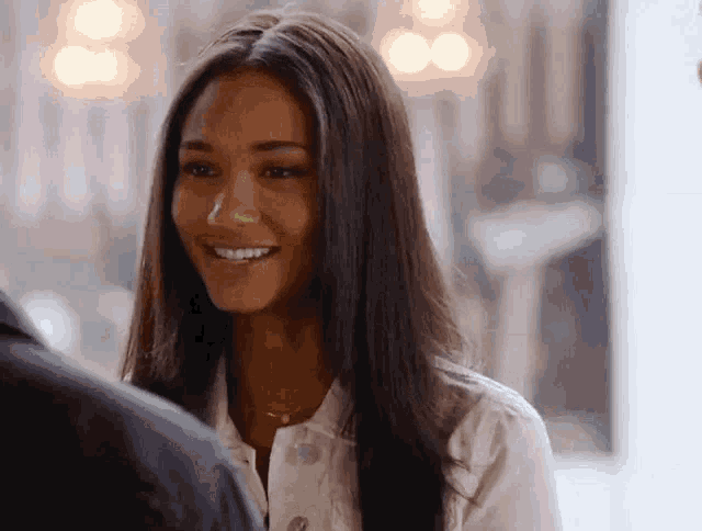 a woman in a white shirt is smiling at a man
