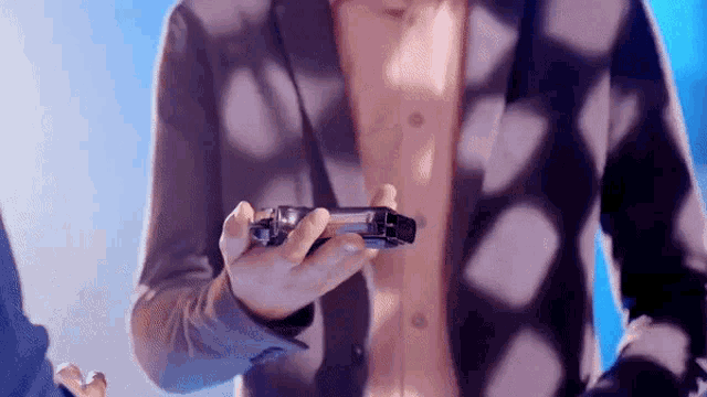 a man in a suit is holding a game controller