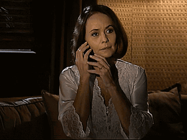 a woman sitting on a couch talking on her cell phone