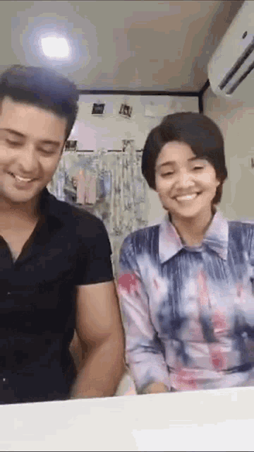 a man and a woman are standing next to each other and smiling .