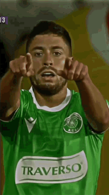 a soccer player wearing a green shirt that says traverso on it