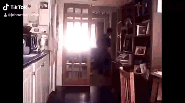 a man is standing in a living room in front of a door .