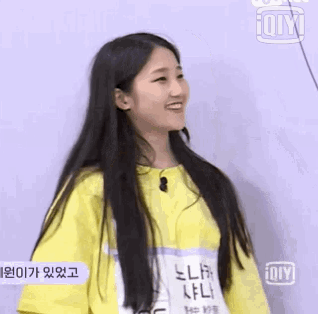 a girl with long hair wearing a yellow shirt with the number j06 on it