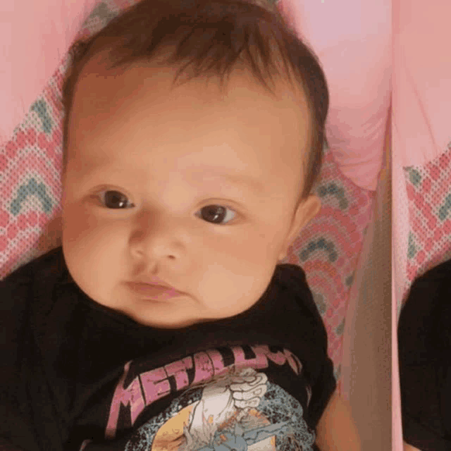 a baby wearing a black shirt that says metallica on it