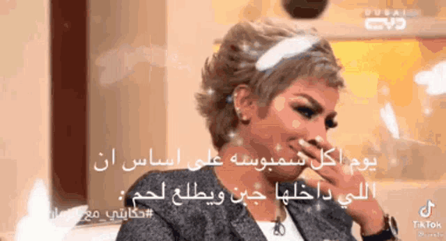 a woman with short hair is covering her mouth with her hand in front of a sign that says tiktok