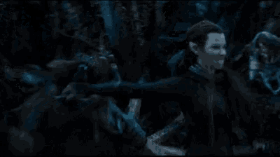 a woman is holding a bow and arrow in the dark .