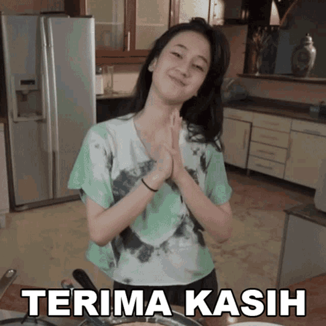 a woman in a kitchen with the word terima kasih on the bottom right