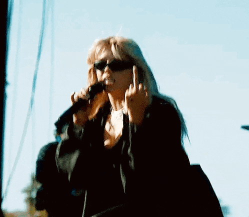 a woman is singing into a microphone on a stage .