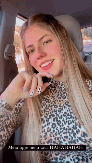 a woman wearing a leopard print shirt is sitting in a car .