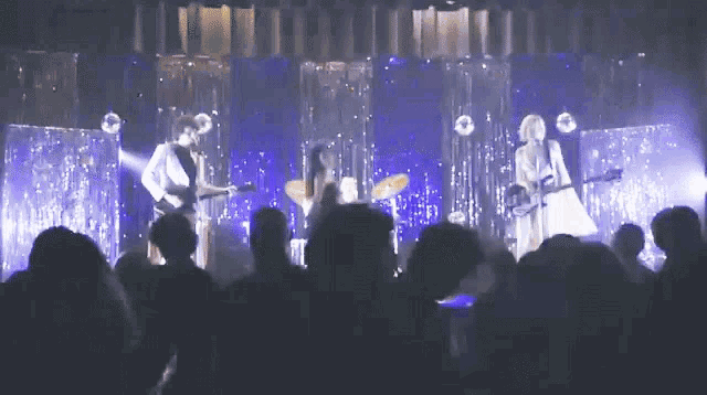 a group of people are playing instruments on stage