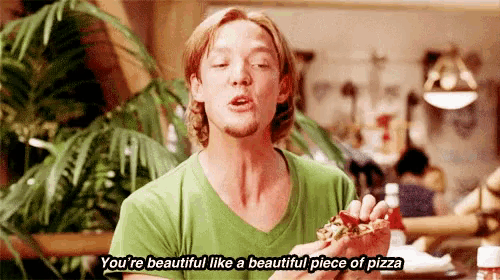 a man in a green shirt is eating a piece of pizza and says you 're beautiful like a beautiful piece of pizza