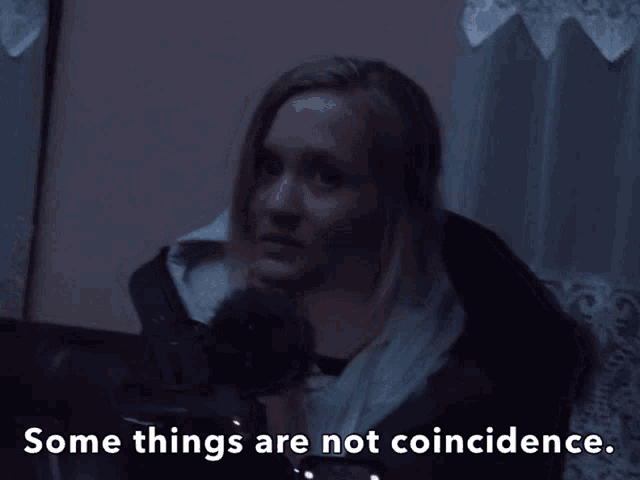 a woman in a dark room with the words " some things are not coincidence "