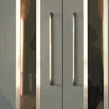 a close up of a door with a reflection of a person behind it