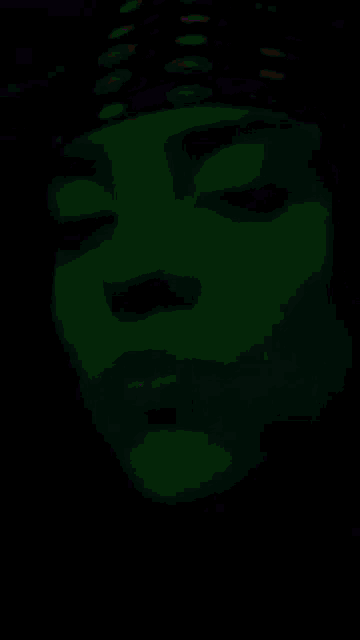 a close up of a person 's face in a dark room with a headband on .