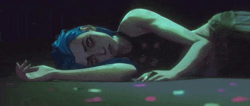 a woman with blue hair laying on the floor
