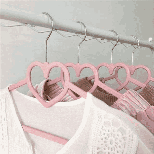 a row of pink heart shaped hangers hanging on a clothes rack