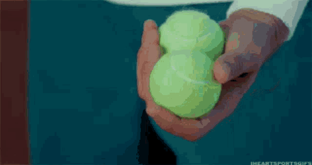 a person is holding two tennis balls in their hands one of which says seven on it