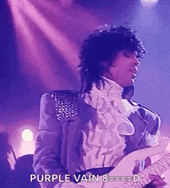 prince is playing a guitar on stage while wearing a purple suit .