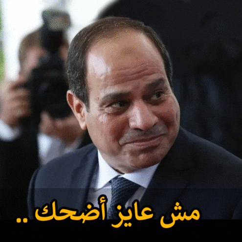 a man in a suit and tie with arabic writing on the bottom right