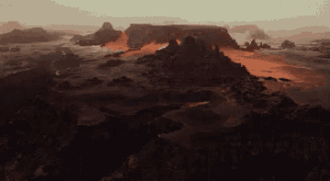 an aerial view of a desert landscape with mountains and a river