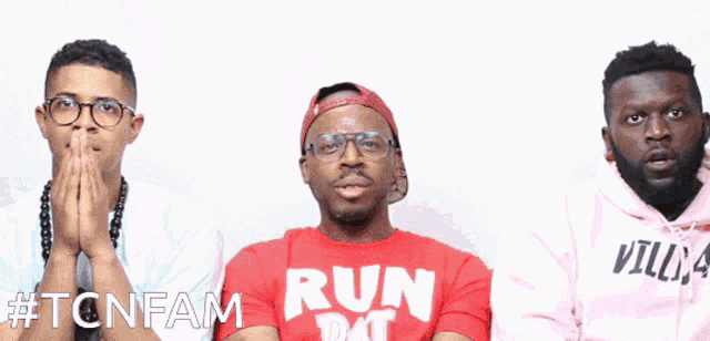 three men are standing next to each other and one of them is wearing a red shirt that says run